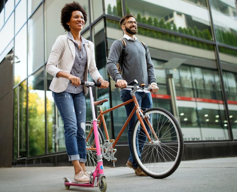 happy-couple-using-electric-scooter-bicycle-in-city-green-eco-energy-concept-with-zero-emission-1.jpg